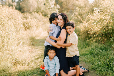 Mom and three boys hugging at the Guelph Arboretum