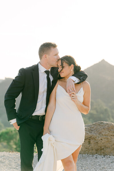 groom kisses bride on the forehead overlooking the mountains in Malibu at Cielo Farms wedding captured by magnolia west photography