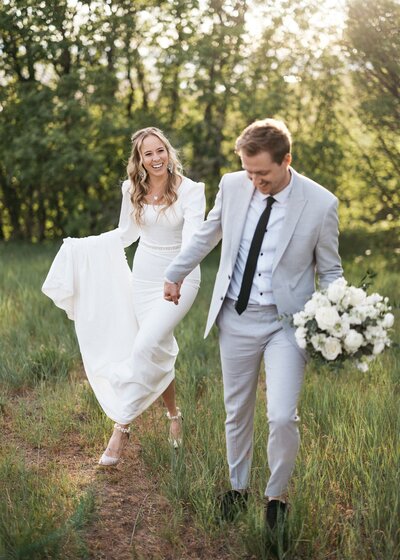 Utah couple taking outdoor wedding photos with white bridal bouquet.