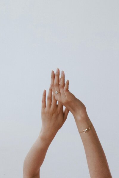 Hands posed gracefully against a neutral background at Maven + Grace Salon in McMinnville, Oregon, representing clean, modern nail care