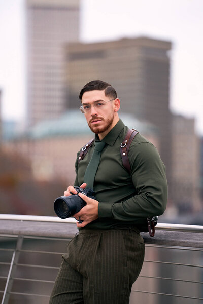 a man infront of tuppor manor with a navy blue banana republic suit