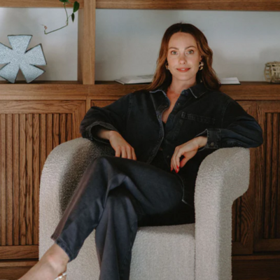 Melissa Vranjes sits on a beige chair.