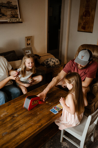 Family playing uno in their livingroom.