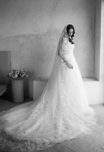 bride getting ready putting on her wedding dress in black and white
