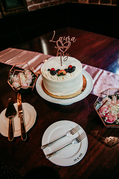 Romantic elopement cake setup with custom topper, florals, and champagne flutes on a styled reception table, captured by San Francisco elopement photographer Kristin Smith.