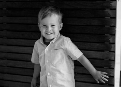 Young boy in black and white portrait with a big smile