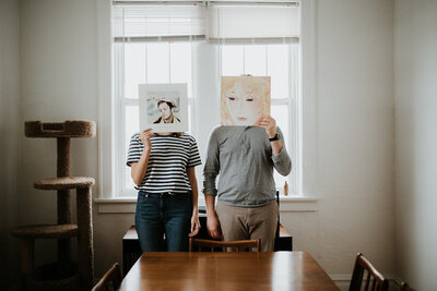 A couple holding records in front of their faces.
