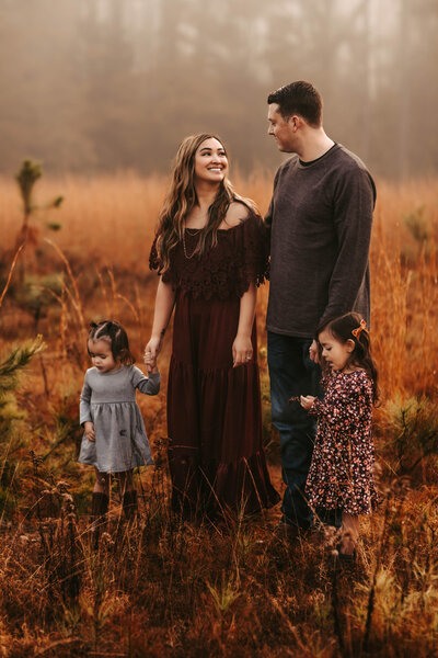 Family of four standing in a foggy field in West GA.