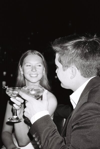 film bar engagement photoshoot for engaged couple. Cheers with champagne toast in green lady lounge in kansas city