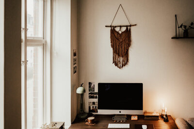 markamé hänger på vägg ovanför dator på en fotografs kontor