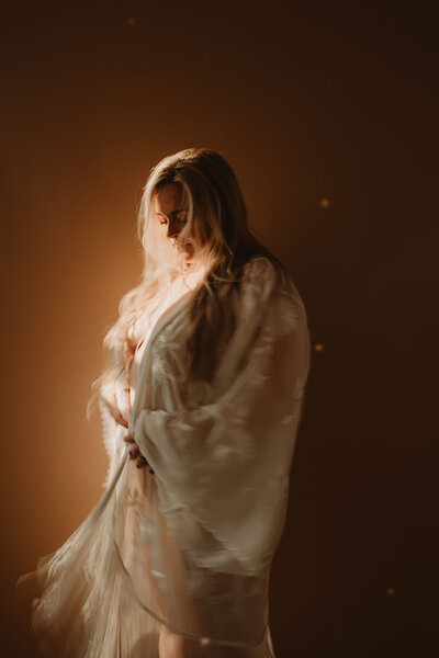 A person in a lacy robe looking down 