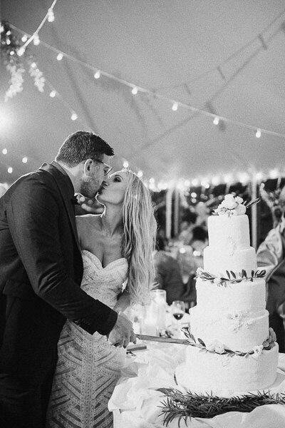 Les mariées s'embrassent en coupant leur gâteau de mariage, photographe mariage montréal.