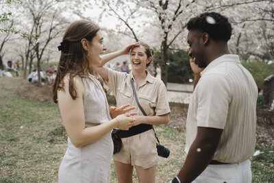 Two people laughing and talking with a photographer outdoors 