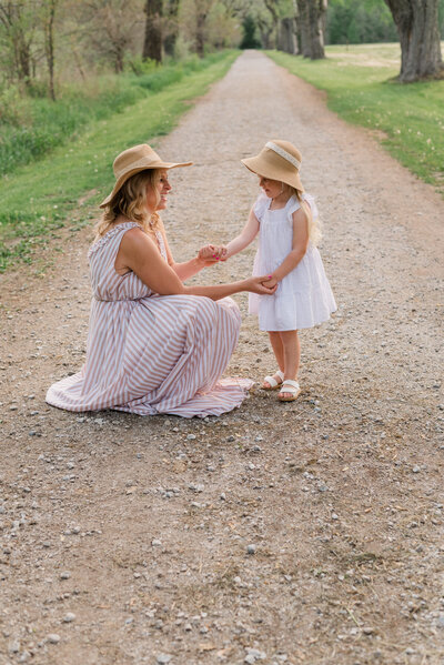 A mother and daughter holding hands and wearing coordinating outfits.