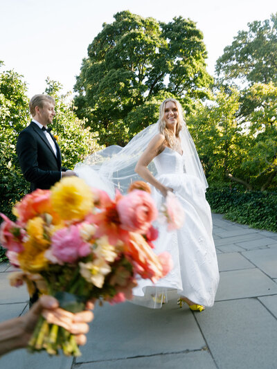 Bride with her bouquet looking off into the distance, the background is all black.