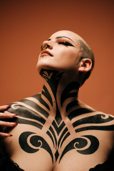 Boudoir  photography of Knoxville Tattoo artist on an orange backdrop