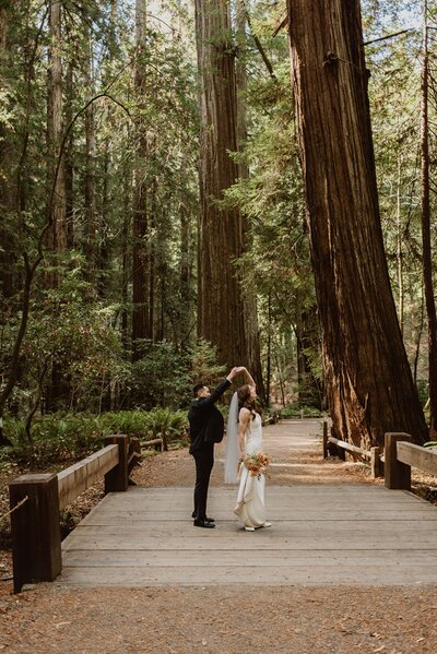 Bride and groom embrace with a kiss in the Mendocino Redwood forest during their all-day elopement