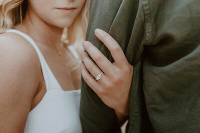 Golden hour engagement ring inspiration of bride holding groom’s arm, taken by Phoenix wedding photographer, Kaylie Miller.