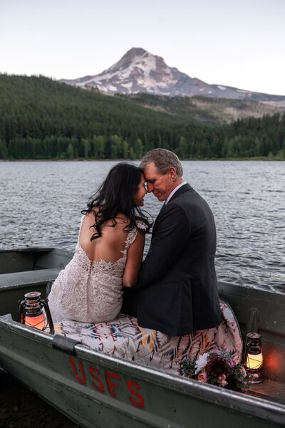 A couple sits in a rowboat in a lake at Mt Hood