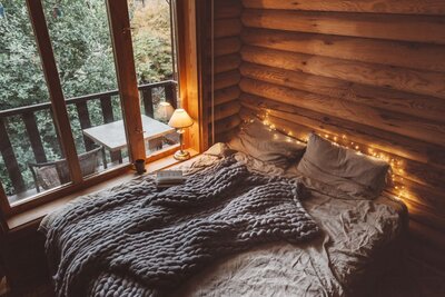 Cozy bedroom with a serene balcony view of pine trees