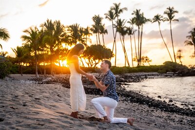 Man down on one knee proposing to his partner on the beach at sunset at the Fairmont Orchid, photographed by Hawaii Adventure Portraits, a Big Island proposal photographer