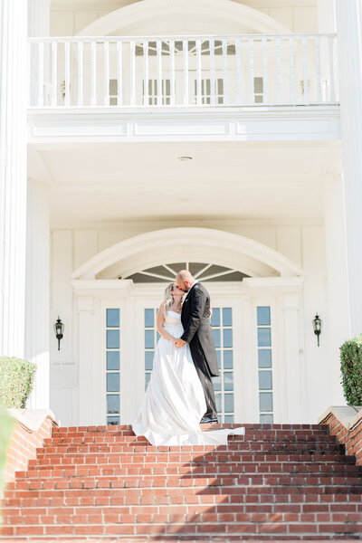 bride being lifted up in an embrace by groom laughing