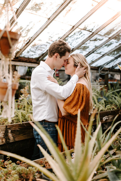 couple embracing in green house photo engagement