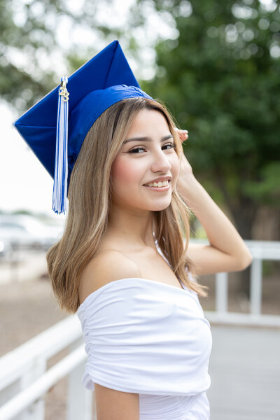 Woman with blue graduation cap smiling