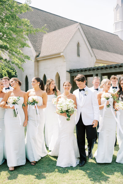 Bride and groom walking away from the camera in grassy field