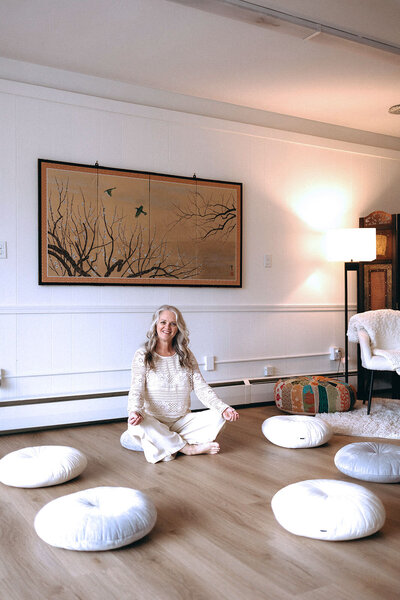 Janna Weldum of Eagle's Guiding Light sits in her meditative circle at The Eyrie smiling warmly.