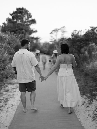 Black and white photo of Courtney Leigh and her husband in the foreground with her kids blurry in the background