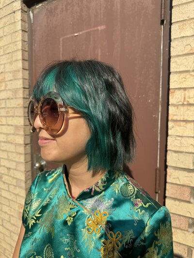 Image of client with black hair that has been dyed blue in the front part of the hair.