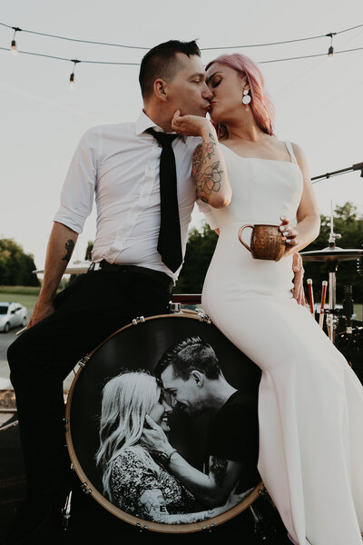 bride and groom kissing on barrel