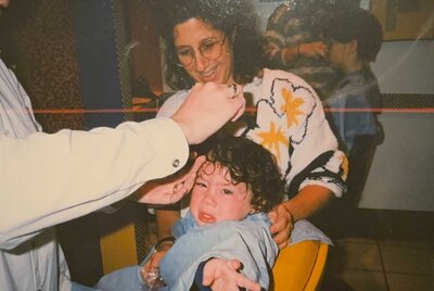 A young boy crying while getting a haircut