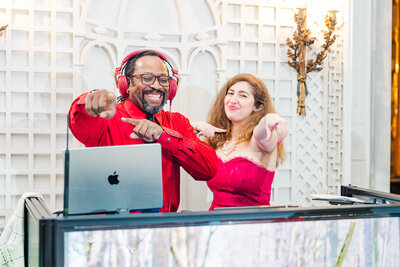 DJ laughing with a guest at the booth, both dancing and enjoying the moment.