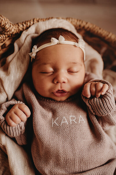 a little one shows off her smiles and coo's during her newborn session in the studio