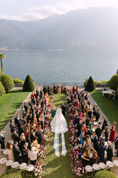 Drone image of bride walking down the aisle in Villa Balbiano Lake Como, in her stunning long-tail Leah Da Gloria gown.