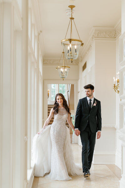 Bride and Groom walking down a white corridor