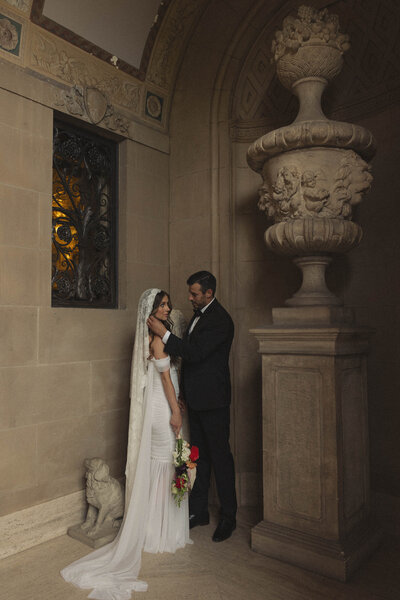 Elegant wedding portrait of a bride and groom in a historic venue, beautifully highlighting the timeless sophistication and romance of their special day