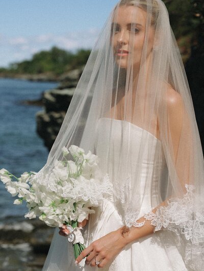 A bride in a white dress, veil and white bouquet