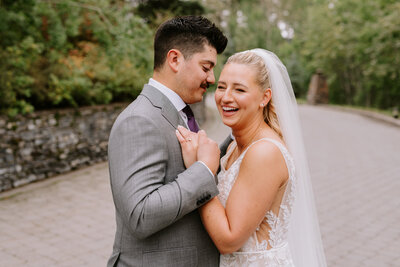 A couple shares a candid moment during their wedding portrait session at Azuridge Estate Hotel in Priddis, Alberta