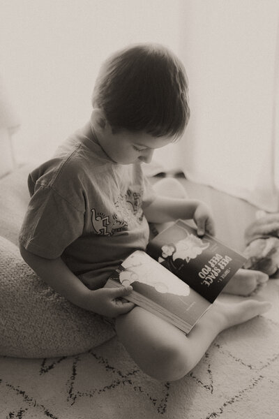 A dreamy black and white image of a young boy reading during his family photo shoot by Coffs Harbour photographer Fire & Fly