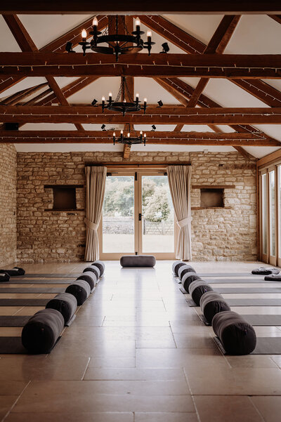 Yoga mats laid out in the barn at Caswell House, set up for a wellness or retreat event
