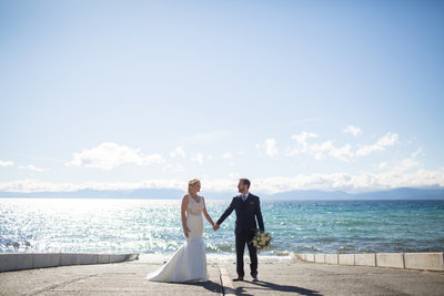 Bride and Groom standing on edge of Lake Tahoe at their destination wedding venue