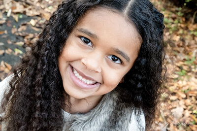 young girl smiling at the camera photographed by Millz Photography in Greenville, SC
