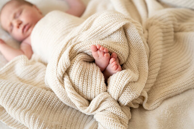 Detailed photo of newborn baby toes wrapped in a blanket
