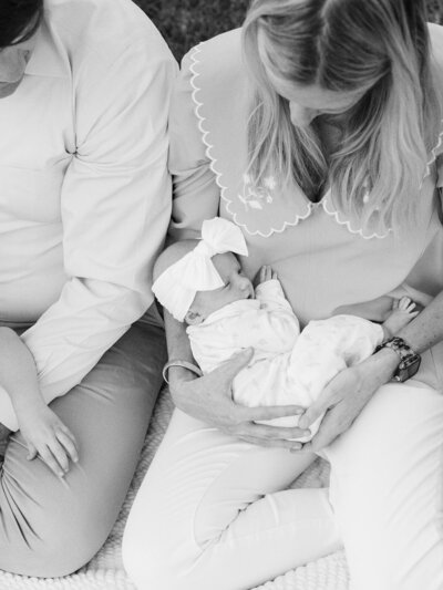 A mother holding a baby and sitting next to the father during a Richmond newborn photography session by Katie Stansfield Photography.
