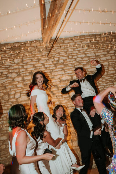 Wedding guests dancing and celebrating on the dancefloor during the reception at Caswell House