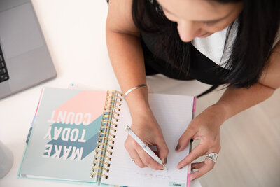 brand photographer making a plan in the notebook for a brand photoshoot