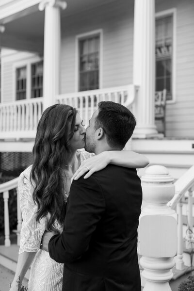 Black and white photo of bride and groom sharing a kiss